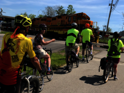 MCC Cycling Council waiting on their bikes for a train to pass