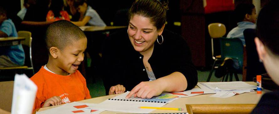 Photo of female student working with a young child